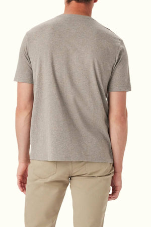 A man faces away from the camera, wearing the RM Williams Parson T-Shirt—a short-sleeve gray cotton crew neck—paired with beige pants against a plain light background.