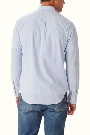 A man shown from the back wears the RM Williams Regular Poplin Stripe Shirt in light blue and white stripes with blue jeans, set against a plain light background.