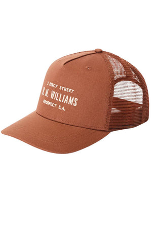 The RM Williams Stencil Trucker Cap features a brown mesh design, curved brim, white stencil graphic on the front, and a snap adjuster at the back and sides for an easy fit.
