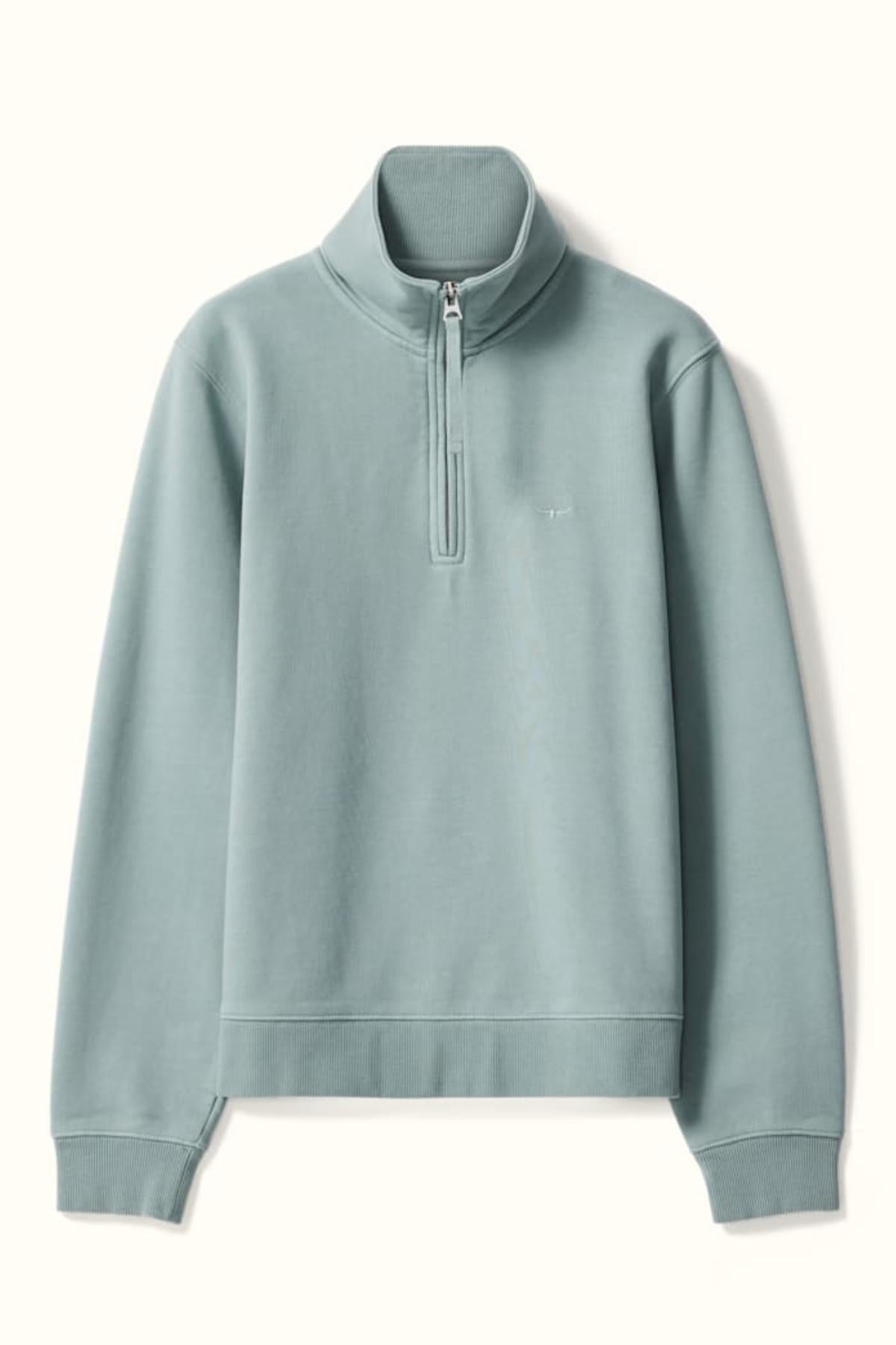 The RM Williams Trickett Zip Neck Sweatshirt is a light blue-green quarter-zip in organic cotton, with a stand collar, long sleeves, ribbed cuffs and hem, and a subtle chest logo.