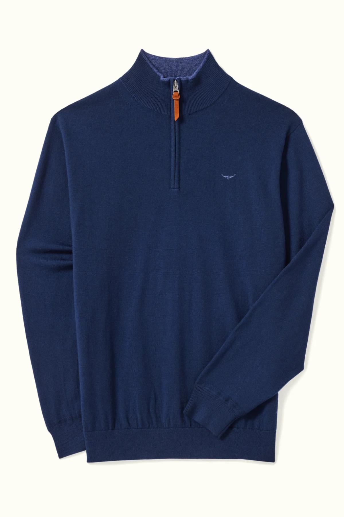 The RM Williams Ernest 1/4 Zip Merino Knit is a navy blue sweater with a ribbed collar, cuffs, and hem, small chest logo embroidery, brown zipper pull, and crafted from soft Merino wool for comfort.