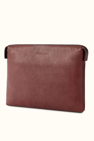 The RM Williams Farrier Tech Case is a brown pouch in soft tumbled grain leather with minimalist design, subtle stitching, embossed logo at the top center, flat sides, and water-resistant lining for added protection.