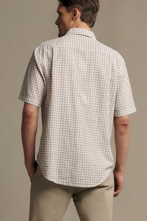A man is shown from the back, standing against a plain background and wearing the RM Williams Johnson Check Short Sleeve Shirt paired with beige pants.