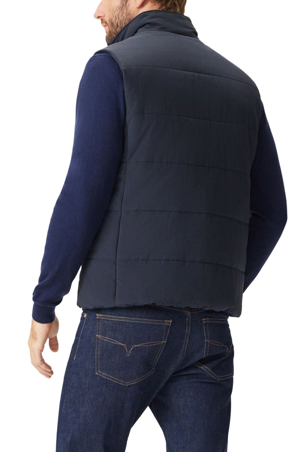 A man shown from the back wearing an RM Williams Padstow Vest in navy blue over a dark blue long-sleeve shirt and blue jeans.
