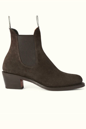 The RM Williams Rosebery Boot is shown in side profile on a light background, featuring dark brown suede leather, a low tapered block heel, elastic side panels, and front and back pull tabs.