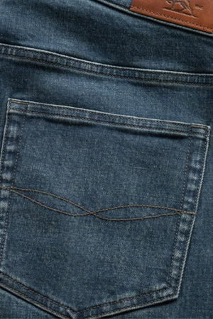Close-up of the back pocket on Rodd & Gunn Kurow Relaxed Fit Italian Denim Jeans, featuring blue Italian denim, visible stitching, and a brown leather patch on the waistband.