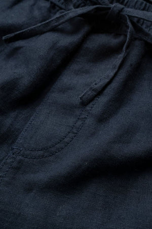 Close-up of Rodd & Gunn Linen Resort Short in dark navy blue, featuring a front pocket, visible stitching, and a drawstring waistband tied in a bow.