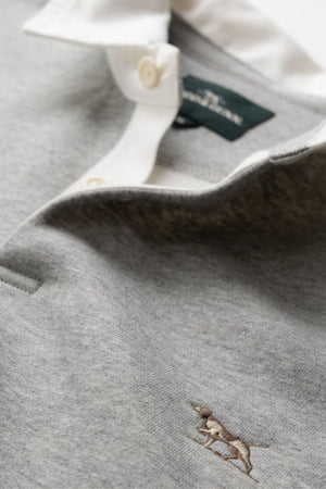 Close-up of the Rodd & Gunn Otago Sweat in light grey, featuring a traditional twill rugby collar with buttons, signature pointer logo embroidered on the chest, and a dark green tag inside the collar.