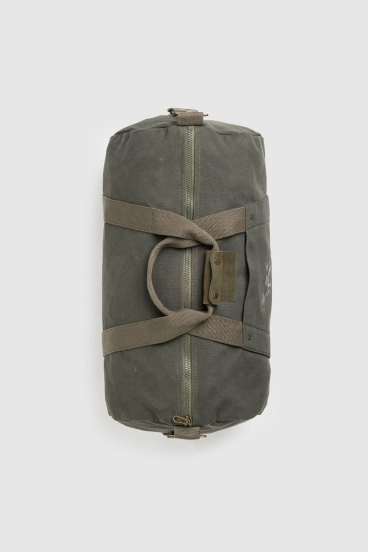 The Rodd & Gunn Ponsonby Road Duffle Bag, made from green cotton canvas with tan straps, a zipper closure, and buttoned handle strap, is shown lying flat on a plain light background.