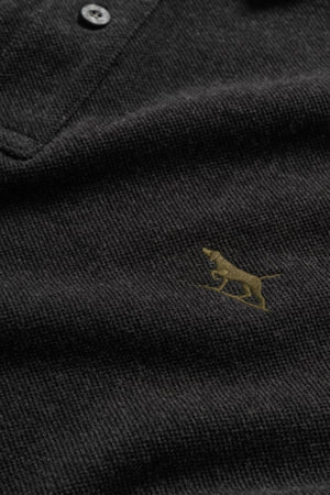 Close-up of the Rodd & Gunn The Gunn Polo, a modern fit made from Australian cotton, featuring two buttons and a small gold embroidered dog logo on the chest.