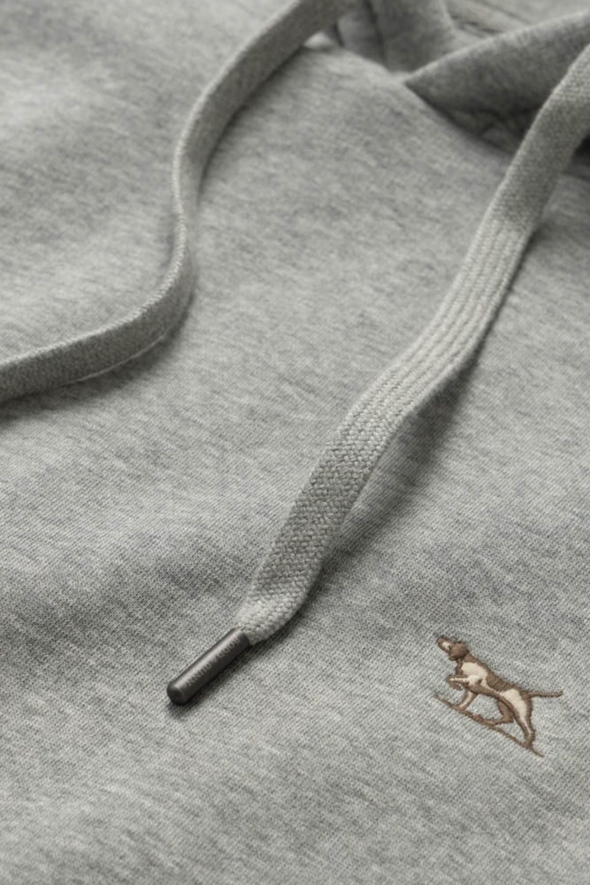 Close-up of a gray Rodd & Gunn Otago Hoodie featuring a drawstring and a small embroidered brown dog logo, crafted from premium Australian Cotton with soft brushed back fleece for enhanced comfort.