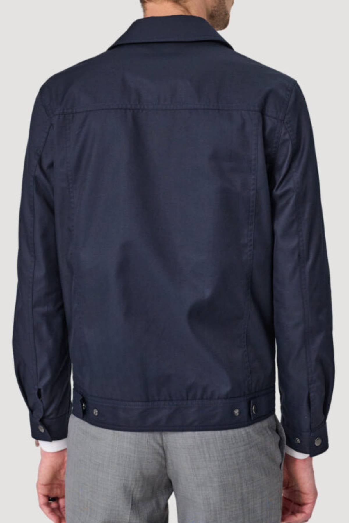 A man is shown from the back wearing a navy blue Savile Row James Zip Front Jacket with a classic collar, buttoned cuffs, and adjustable side tabs at the hem, paired with light gray pants.