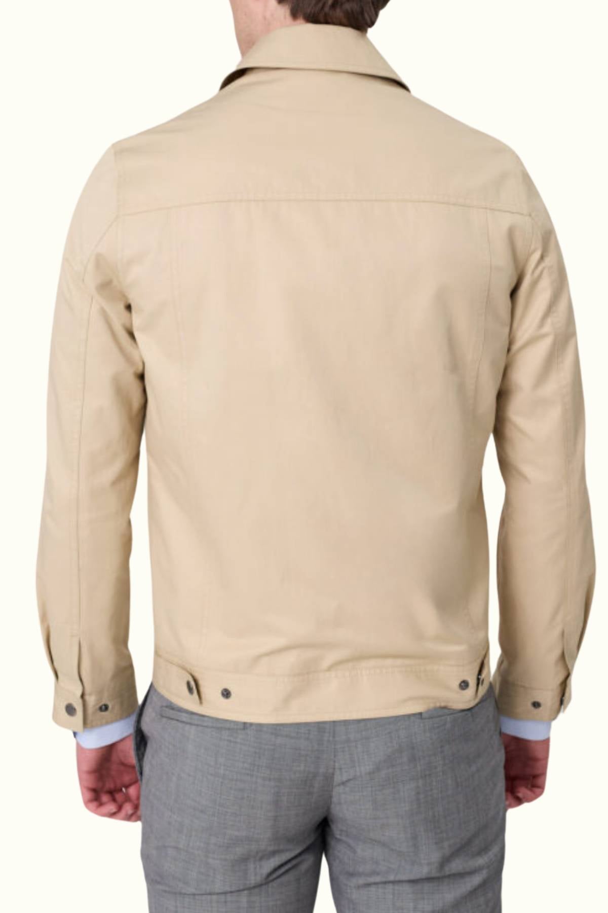 A man is shown from the back, standing against a plain light background, wearing the Savile Row James Zip Front Jacket—stylish, comfortable, and crafted from 100% cotton—with gray trousers.