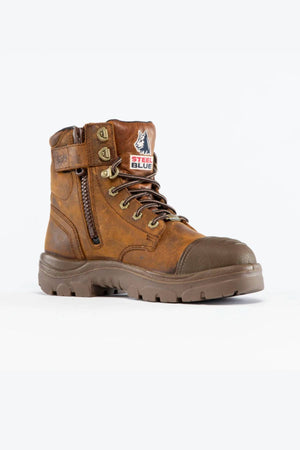 The Steel Blue Argyle Zip Scuff Cap Waterproof Boot is a brown leather boot with black sole, side zipper, laces, steel toe cap, and tongue patch displaying the Steel Blue wolf logo. Features Trisole Comfort Technology for all-day support.