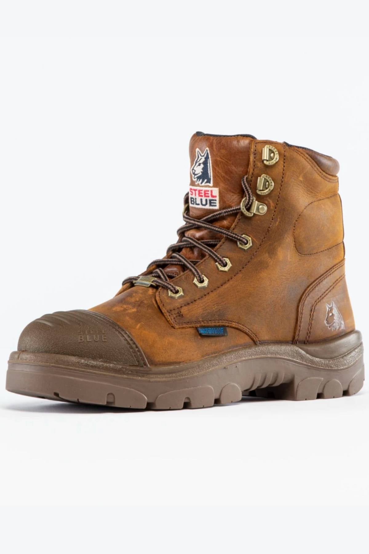 The Steel Blue Argyle Zip Scuff Cap Waterproof Boot features a high ankle, sturdy Trisole Comfort sole, reinforced toe, dark brown laces, and logo patches, shown angled on a white background.