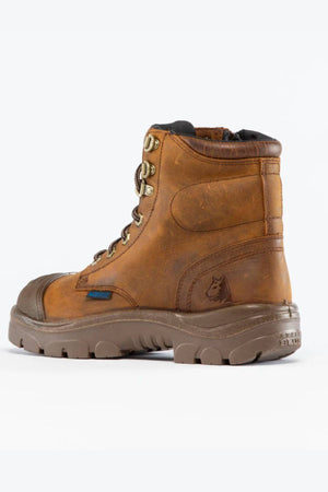 The Steel Blue Argyle Zip Scuff Cap Waterproof Boot features brown leather, a rugged sole, steel toe cap, metal eyelets, a wolf logo embossing, and Trisole Comfort Technology. Displayed on a plain white background.