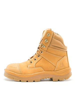 The Steel Blue Southern Cross Zip Boot is a tan, high-ankle boot with a rugged sole, metal eyelets, visible stitching, water-resistant leather, and a safety steel toe. It is shown from the side against a white background.