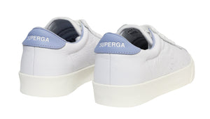 The Superga 2843 Club S Comfort Leather Sneakers feature white leather with light blue heel accents and the brand name in white text. A thick vulcanized gum sole ensures style and durability, captured beautifully from a rear three-quarter angle.