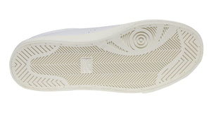 The image displays the sole of a white Superga 2843 Club S Comfort Leather Sneaker, featuring a vulcanised gum sole with a geometric pattern, herringbone grooves for traction, and a circular design at the heel.