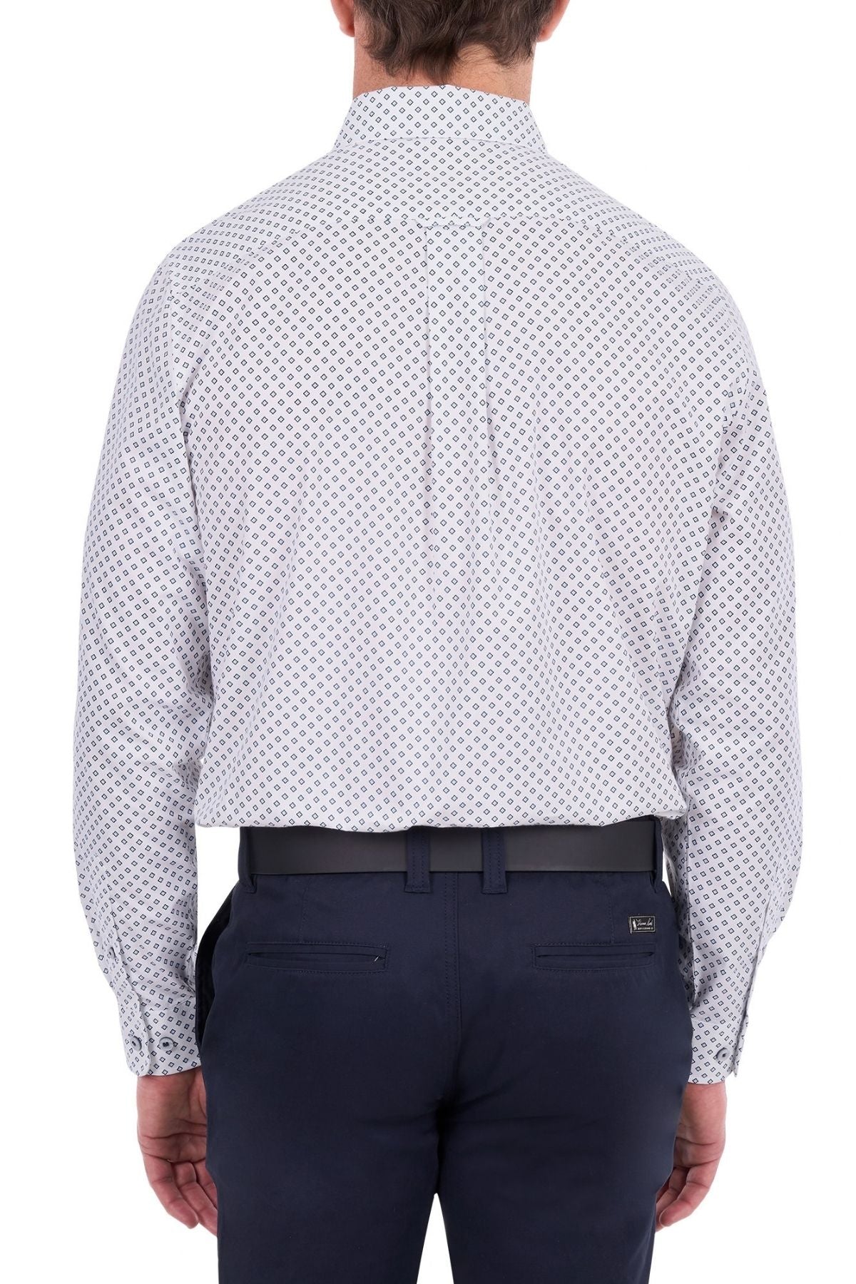 A man is shown from the back, wearing the Thomas Cook Albie Shirt—a long-sleeve, light-colored patterned workwear shirt—tucked into dark blue dress pants with a black belt.