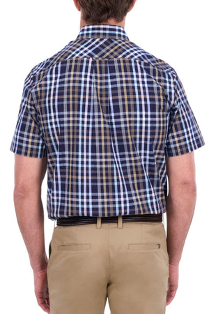 A man shown from the back against a white background wears the Thomas Cook Finley Short Sleeve Shirt, featuring blue and brown plaid workwear style, paired with tan pants.