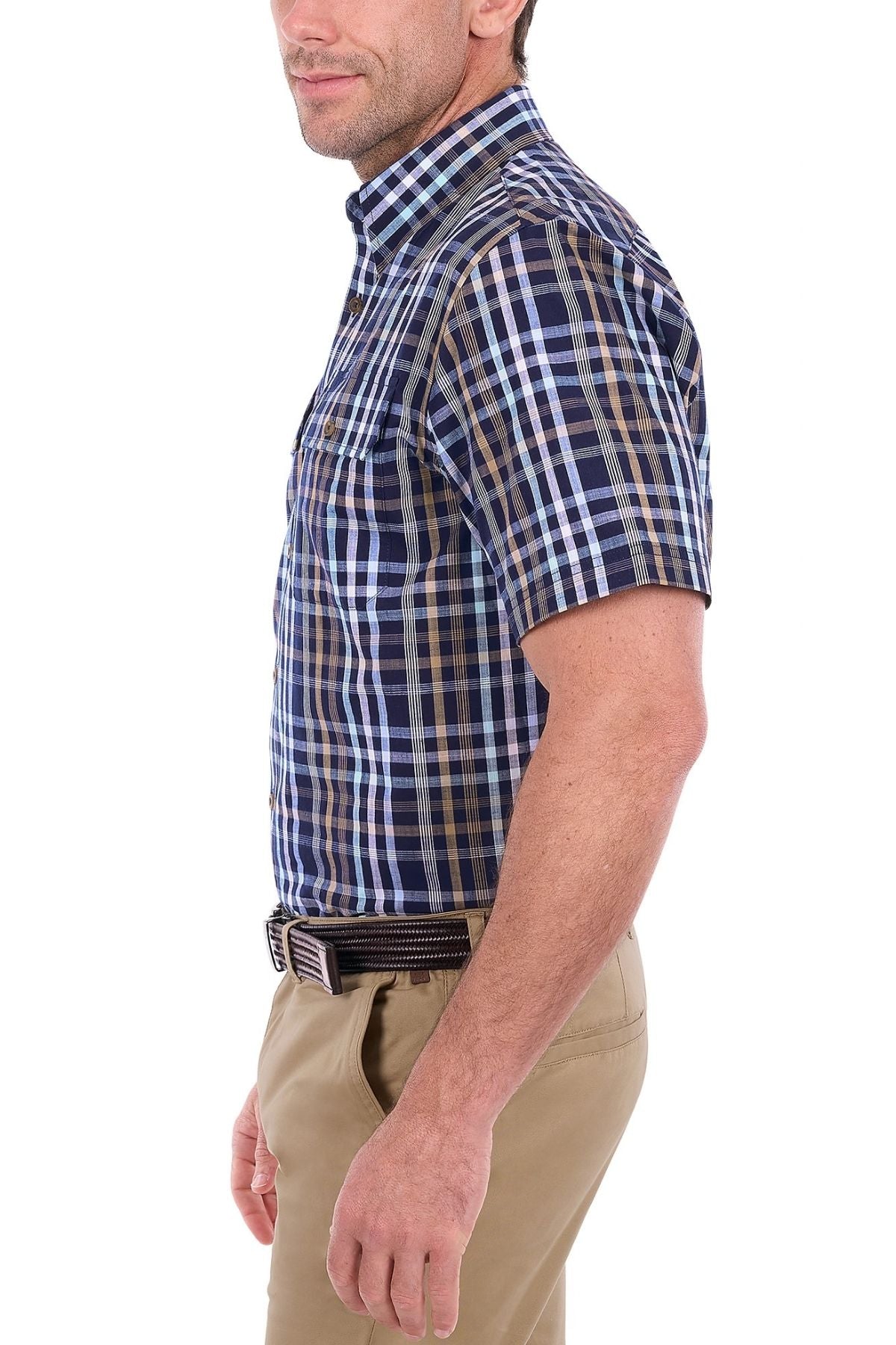 A man in the Thomas Cook Finley Short Sleeve Shirt, featuring blue and brown plaid workwear style, and khaki pants, standing in profile against a white background.