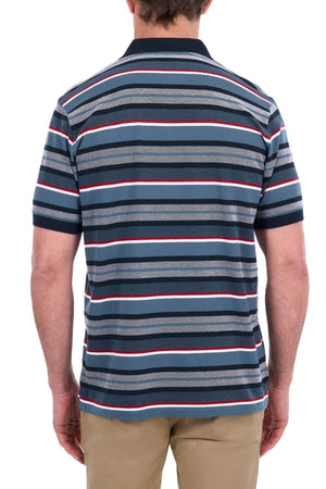 A man is seen from behind wearing the Thomas Cook Glenn Polo, a short-sleeved, collared shirt with horizontal stripes in blue, white, red, and gray, paired with tan pants.