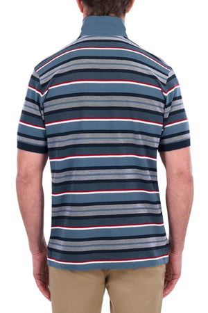 A man, seen from behind, is wearing the Thomas Cook Glenn Polo—a short-sleeved collared shirt designed in a classic multi-colour stripe pattern of blue, gray, white, and red—and tan pants.