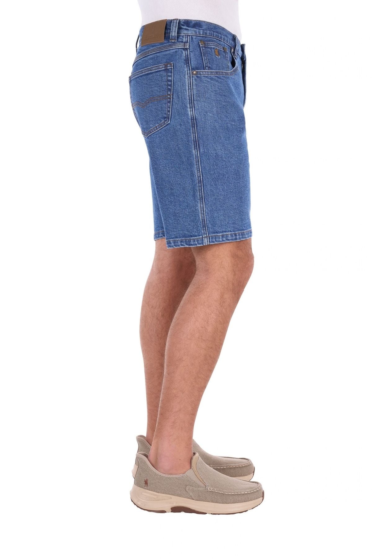 A person wearing Thomas Cook Lochie Shorts and beige slip-on shoes, standing sideways against a white background.