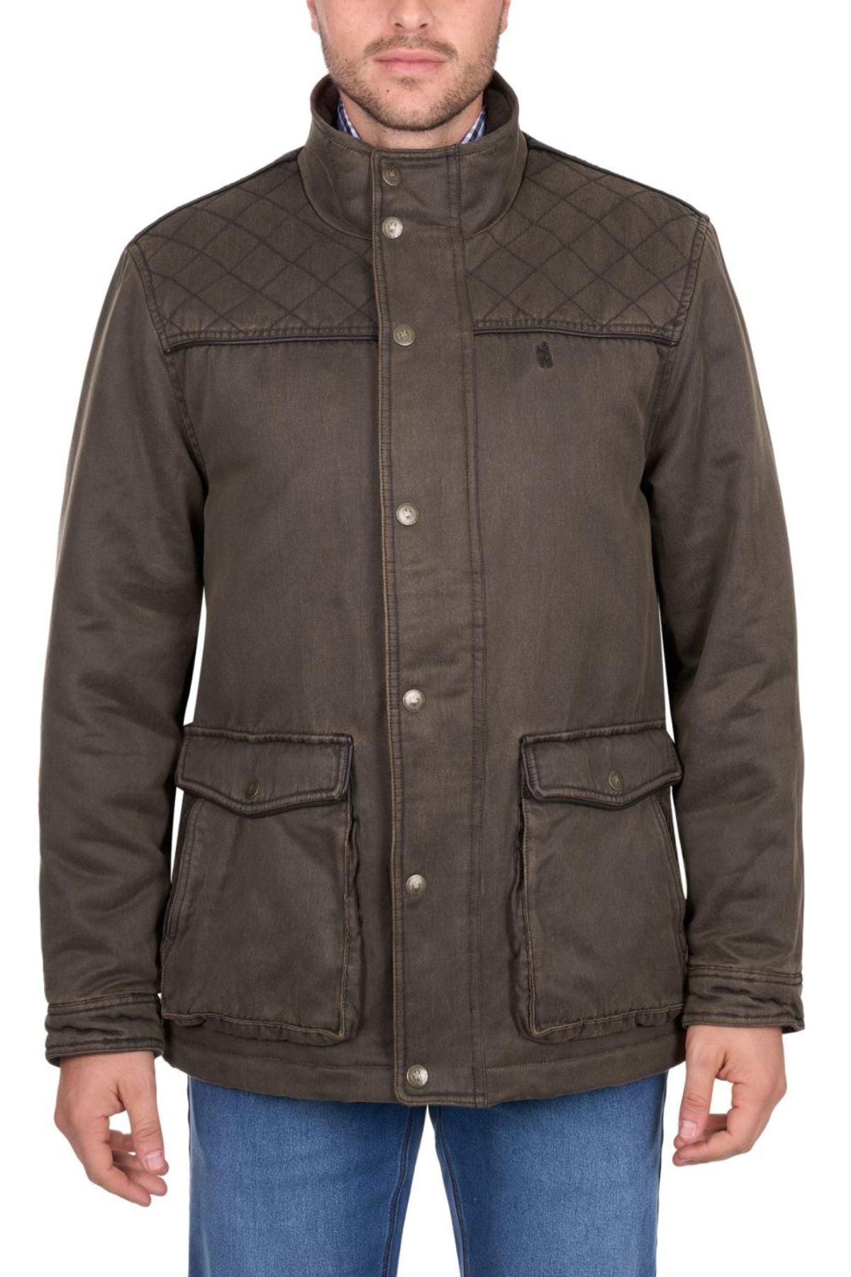A man wears the Thomas Cook Marcus Jacket, a brown quilted faux oilskin style with button closures and two large front pockets, paired with blue jeans. The image is cropped below his nose, obscuring his eyes.