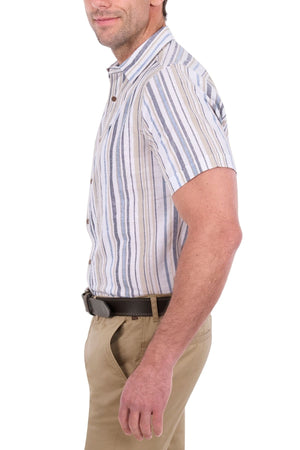 A man wearing the Thomas Cook Max Short Sleeve Shirt with stripes and khaki pants stands sideways, his left hand in his pocket, against a white background.