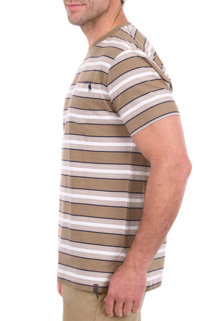 A man stands sideways, facing left, wearing the Thomas Cook Nick Tee in beige, white, and gray classic stripes. His upper body is visible against a white background, highlighting the soft cotton jersey fabric and subtle horseman embroidery on the chest.