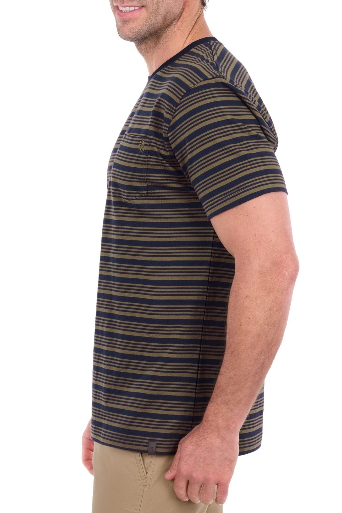 A man stands sideways with a slight smile against a plain white background, wearing the Thomas Cook Oliver Tee—a navy and olive striped t-shirt crafted from soft cotton jersey and featuring a subtle chest pocket.