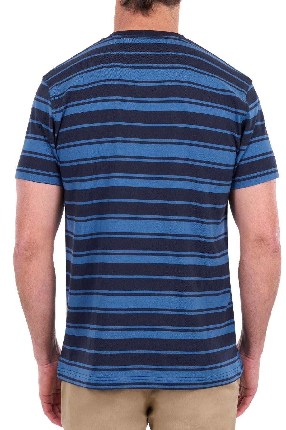 A person is shown from the back standing against a white background, wearing the Thomas Cook Pete Tee—crafted from soft blue and black striped cotton jersey—and beige pants.