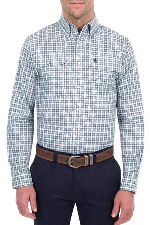 A man is wearing the Thomas Cook Rory Shirt, a green and white plaid cotton check shirt with long sleeves featuring front pockets and a small embroidered logo. He pairs it with dark pants and a brown belt, standing against a white background.