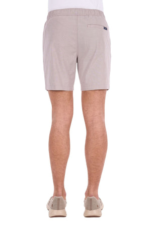 A person is shown from the back against a white background, wearing light beige Thomas Cook Rowan Shorts crafted from premium textured fabric and paired with beige shoes.