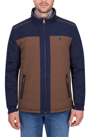 A man wears the Thomas Cook Toby Reversible Jacket with navy sleeves and shoulders, brown front and back panels, zippered front and pockets, paired with blue jeans. Only the lower part of his face is visible.