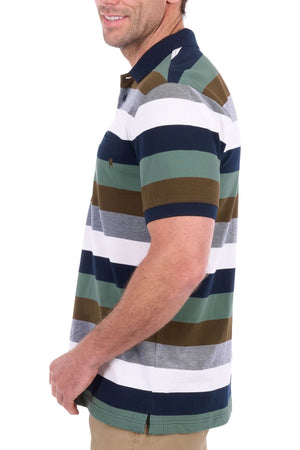 A man wearing the Thomas Cook Wayne Polo—crafted from 100% cotton pique with multi-colour stripes—and khaki pants stands sideways, smiling against a white background.