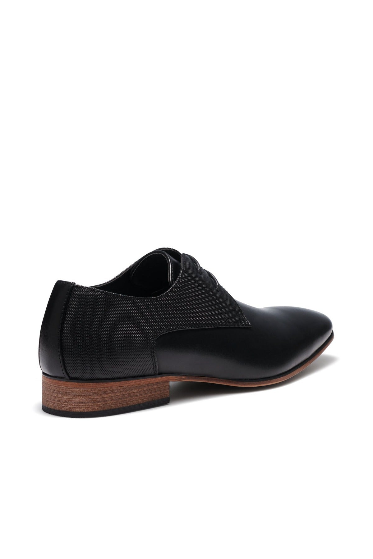 Introducing the UNcut Chartwell Shoe—ideal for formal events. This black dress shoe features a sleek design with an embossed upper panel and contrasting brown sole, complemented by a low heel, laces, and subtle textured pattern for added sophistication.