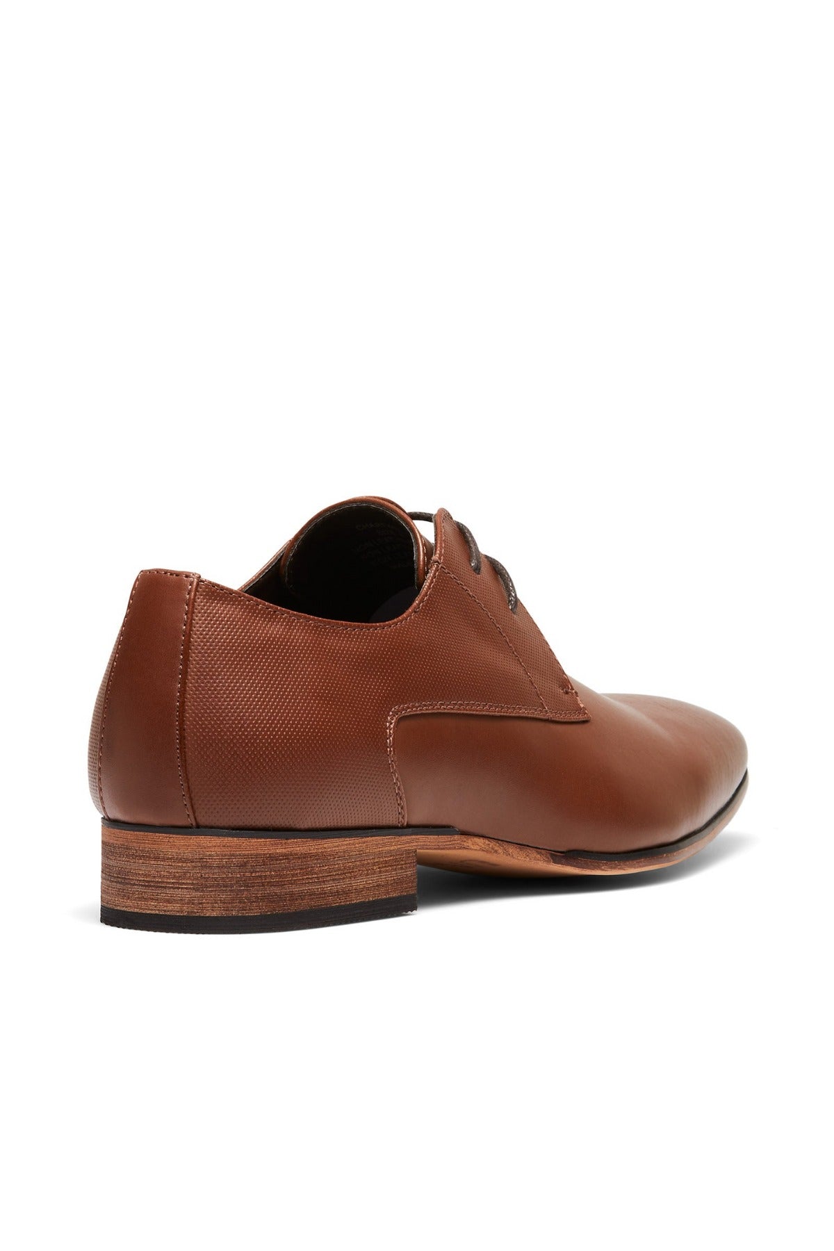 The UNcut Chartwell Shoe is a brown leather dress shoe with a textured finish, perfect for formal occasions. It features a wooden heel and sleek silhouette, showcased from the back and side against a plain white background.