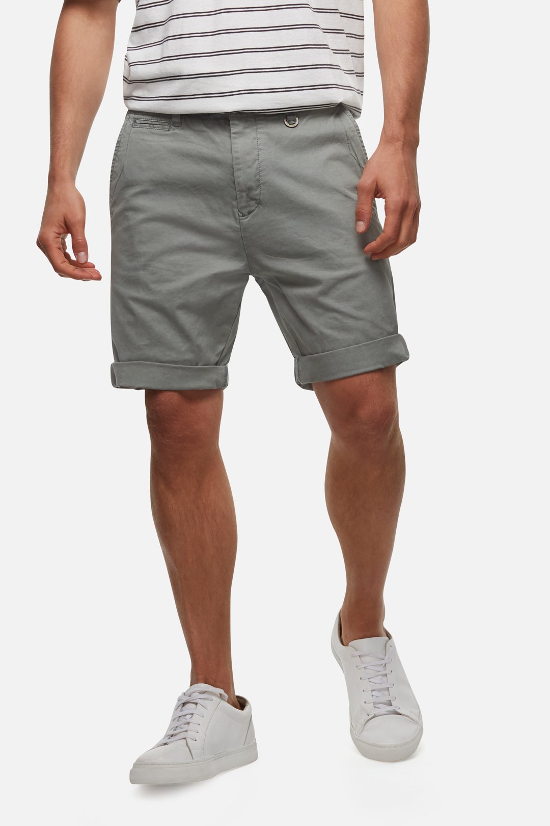 A person wearing the comfortable Industrie The Rinse Short in gray, paired with a white and gray striped shirt and white sneakers. The individual is standing with hands relaxed at the sides against a white background.