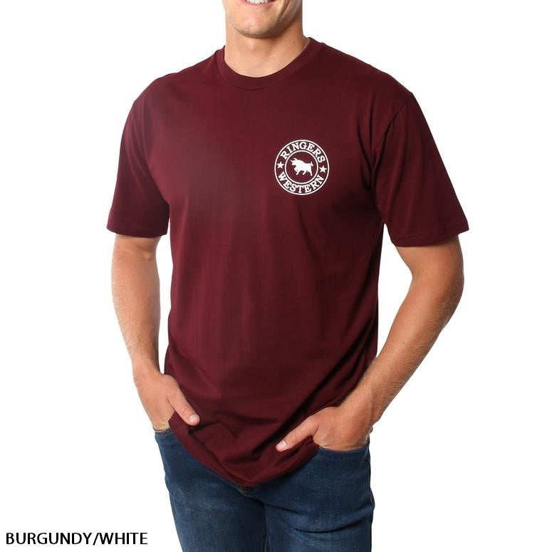 A person wearing the Ringers Western Signature Bull Original Fit T-Shirt in burgundy, made of 100% cotton, featuring a white circular logo with a bull and the text "Ringers Western" on the left chest. One hand is in their pocket while the other hangs by their side. Text reads "BURGUNDY/WHITE.
