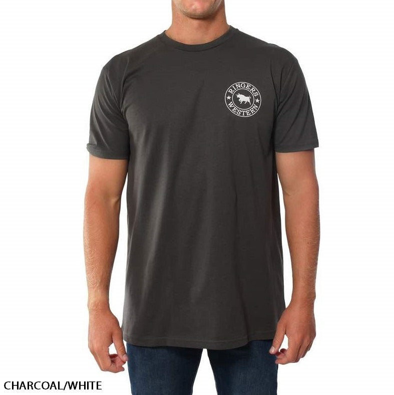 A person wearing a Ringers Western Signature Bull Original Fit charcoal-colored short sleeve t-shirt with a circular white logo on the upper left. The comfortable 100% cotton shirt text reads "CHARCOAL/WHITE" at the lower left corner. The person is also wearing dark blue jeans.