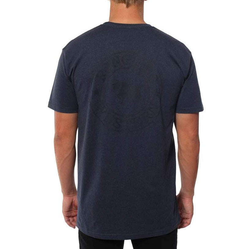 A person with short hair is wearing a comfortable navy blue Ringers Western Signature Bull Original Fit T-Shirt made of 100% cotton, featuring a subtle circular graphic on the back. The person is standing with their back facing the camera against a plain white background.