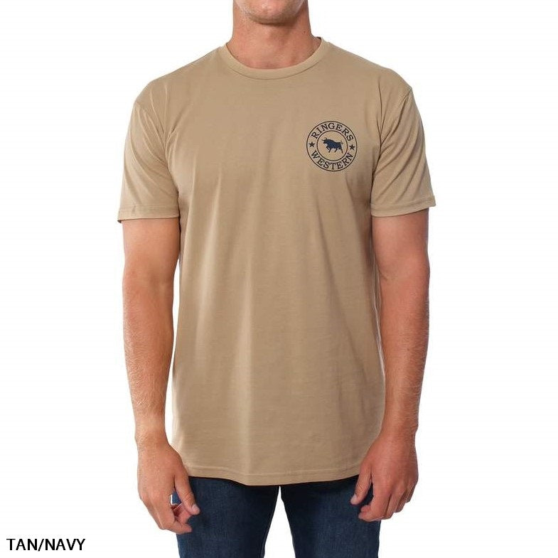 A person is wearing a comfortable Ringers Western Signature Bull Original Fit T-Shirt in tan, featuring a short-sleeved design and a navy circular logo with text and an image of a bull on the left chest. The person is also wearing dark blue jeans. The text "TAN/NAVY" is in the bottom left corner.