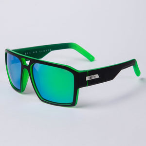 UNIT Vault Polarised Eyewear features green and black frames with polarised, reflective blue-green lenses, thick and lightweight design, bright green inner arms, and "UNIT" branding on the arms, displayed on a white background.