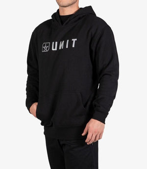 Wearing the UNIT Stride Fleece Hoodie—a comfy black hoodie with a front pocket, reversed white "UNIT" text, and a small graphic—a person stands against a plain white background.
