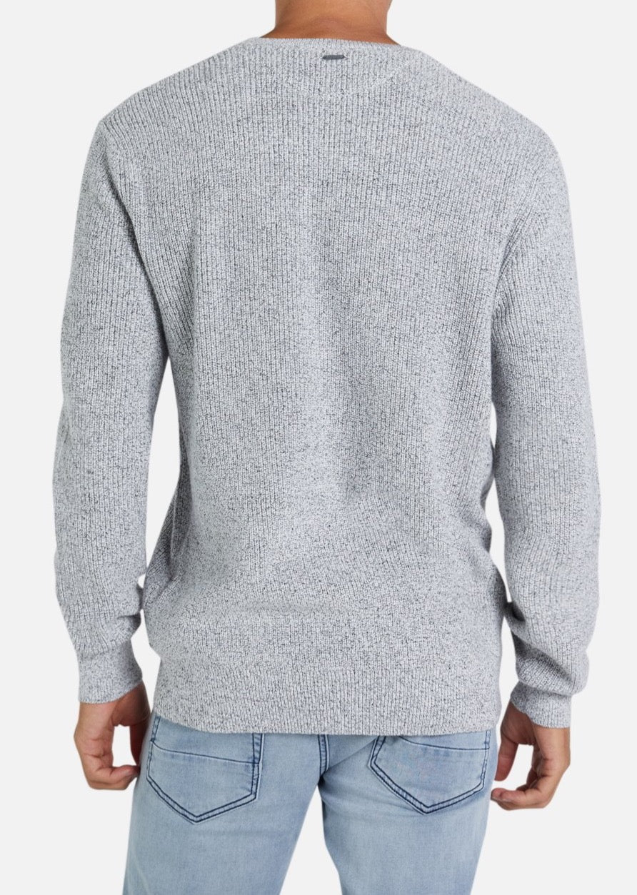 Someone models the Industrie The Kingston Knit, a light gray long-sleeve sweater with waffle knit detail, paired with light blue jeans and shown from behind against a plain white background.