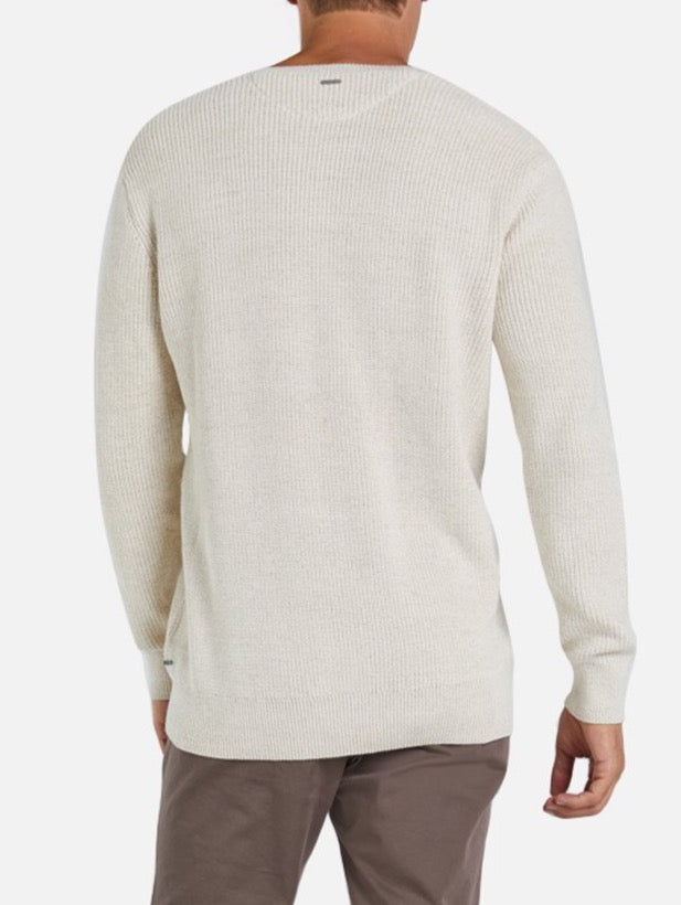 The image shows a person wearing Industrie The Kingston Knit, a light beige waffle knit, long-sleeved sweater made from 100% cotton, paired with brown pants, seen from the back against a plain white background.