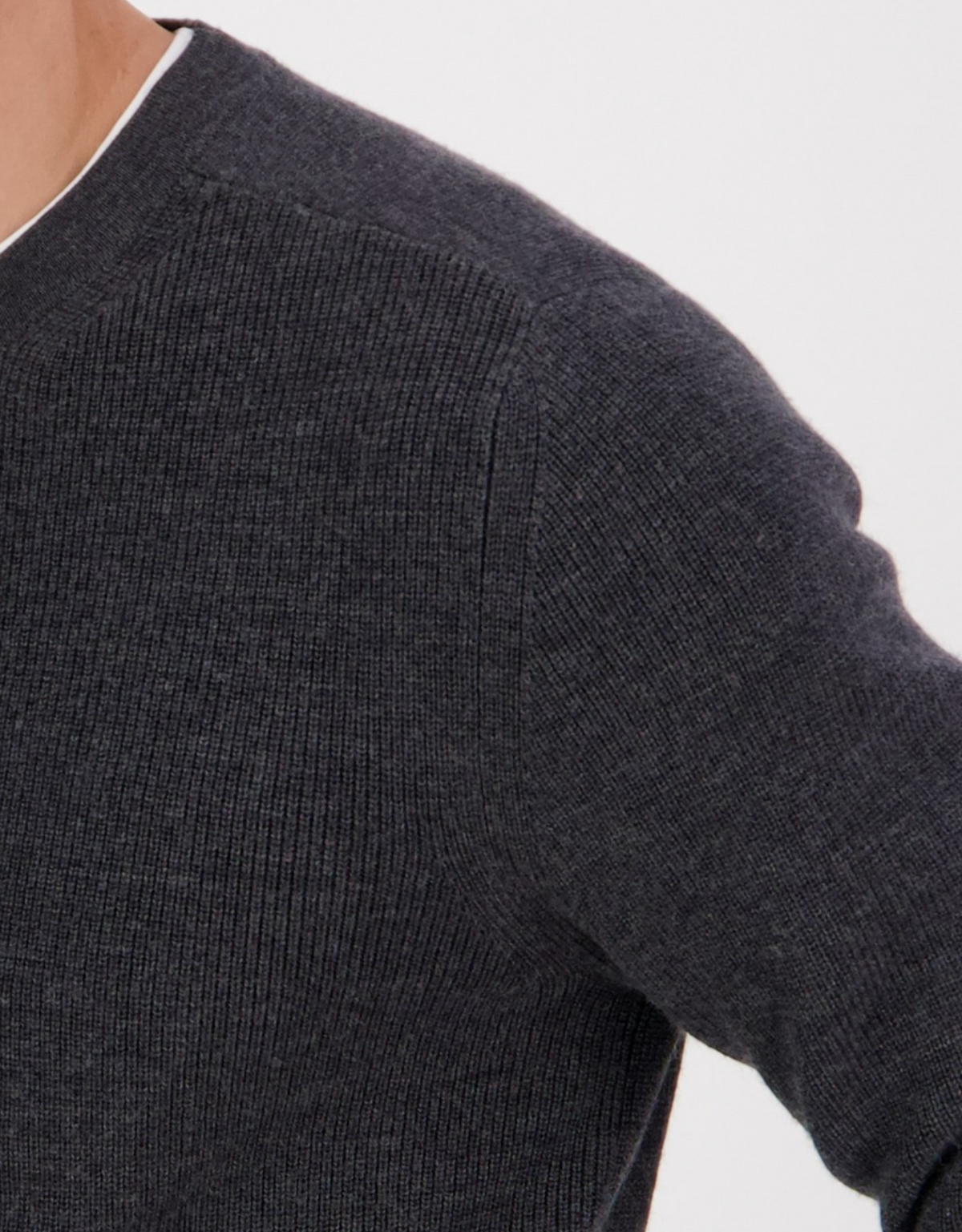 A close-up of a person wearing the Swanndri Otahu River Crew Neck Merino Knit in dark gray, showing just the shoulder, upper arm, and neck against a white background—ideal for referencing your half chest size.